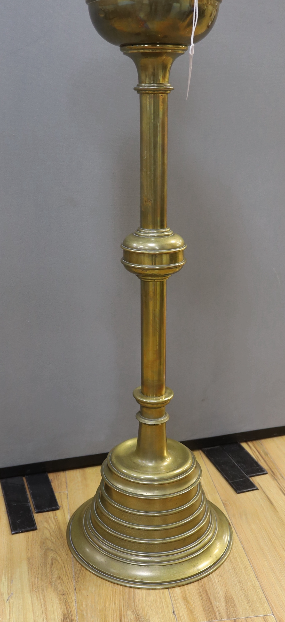 A large brass ecclesiastical candlestick with gothic border, 98cm high